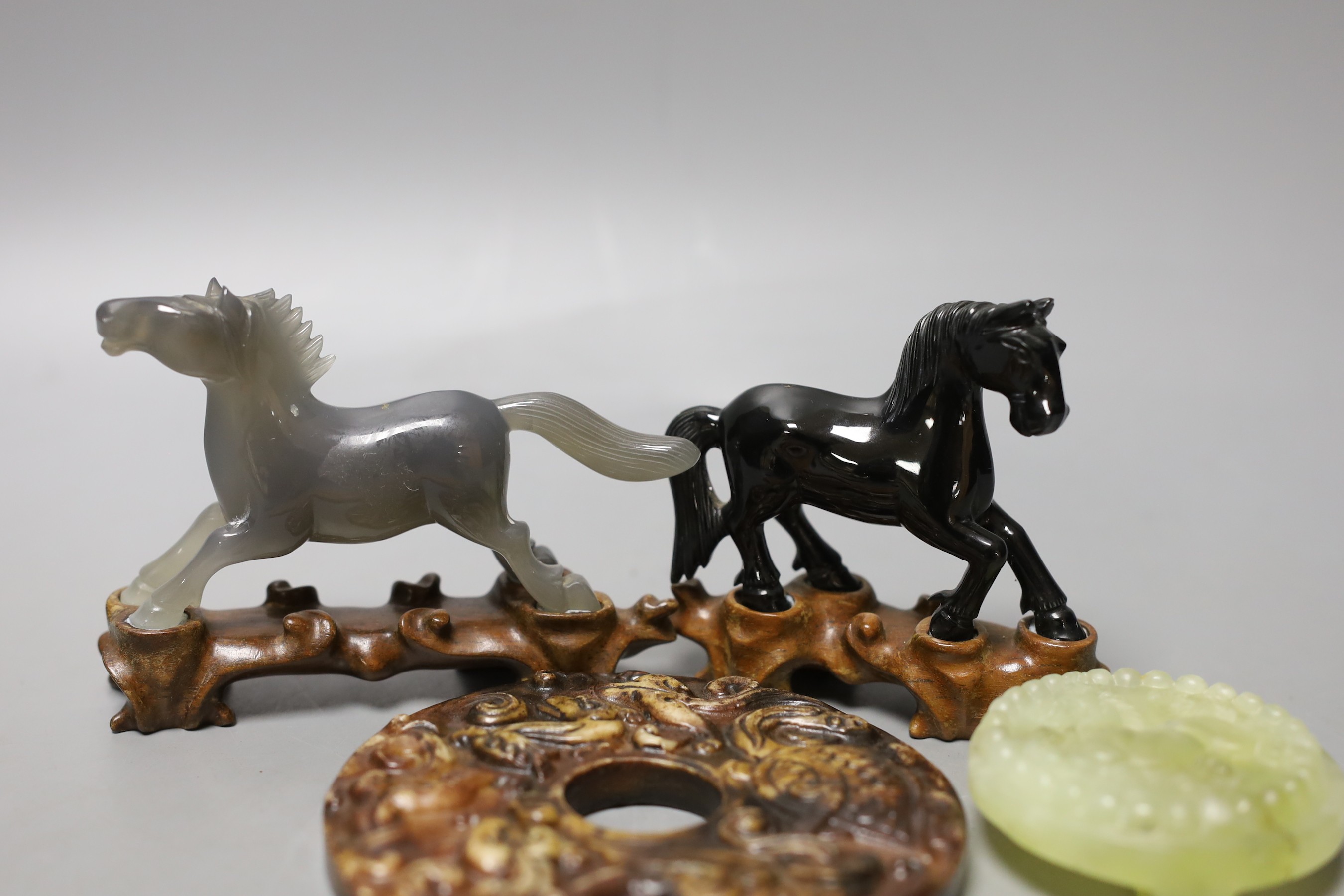 A group of Chinese hardstone plaques, two horse figures, a bi disc and a belt plaque (7)